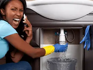 Emergency plumbing repair for a leaking sink drain under a bathroom vanity in Dallas, TX