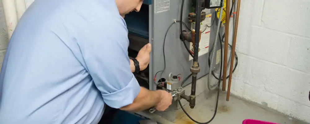 Furnace repair technician inspecting and servicing a home heating system in Dallas, TX