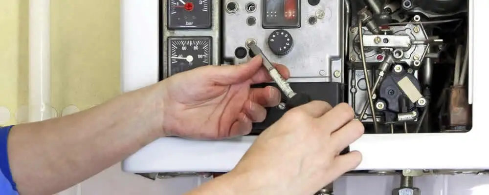Heating repair technician adjusting boiler controls and components in Dallas, TX