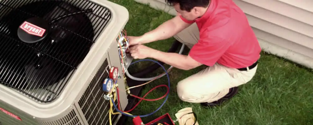 HVAC technician servicing an outdoor air conditioner unit in Dallas, TX