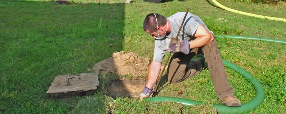 Septic pumping technician servicing a residential septic tank in Dallas, TX